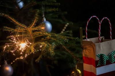 Close-up of sparkler by christmas tree