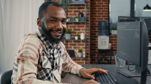 Portrait of young man with computer at table