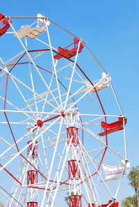 Low angle view of ferris wheel against clear blue sky