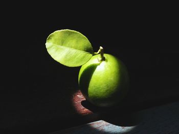 Close-up of apple on table against black background