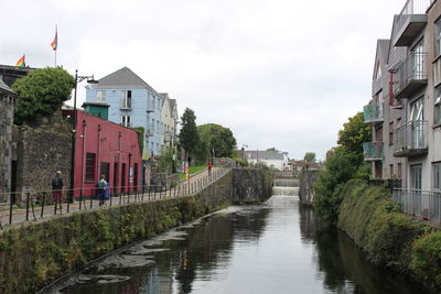 Canal amidst buildings in city, galway