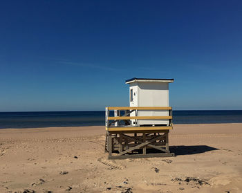 Lifeguard hut on beach against clear sky