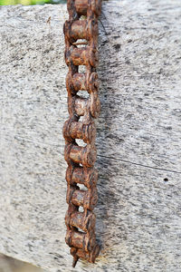 Close-up of rusty chain on wooden post