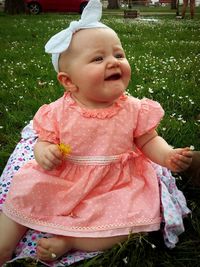 Portrait of cute baby girl sitting outdoors