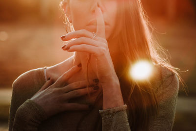 Midsection of woman holding hands outdoors