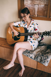 Young woman sitting on sofa at home