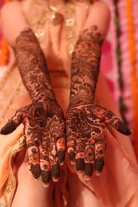 Midsection of bride showing henna tattoo