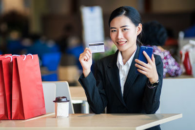 Portrait of a smiling young woman using smart phone