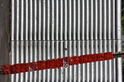 Close-up of text on metal gate against wall