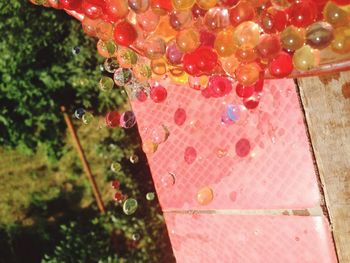 Close-up of wet colorful silicone balls falling from container