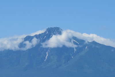 Scenic view of snowcapped mountains against blue sky