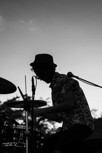 Man playing drums against sky