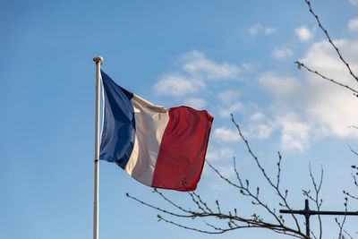 Low angle view of flag against blue sky