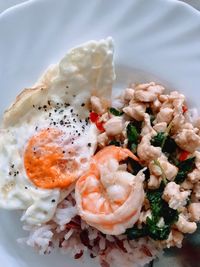 High angle view of fried chicken and shrimp with basil leaves ,famous thai food served in plate.