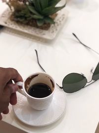 Person holding coffee cup on table