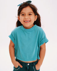 Portrait of young woman standing against white background