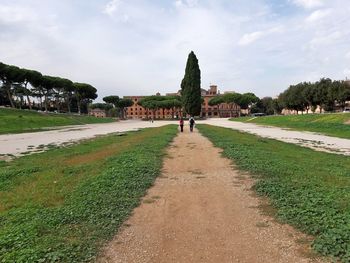 Footpath in park against sky