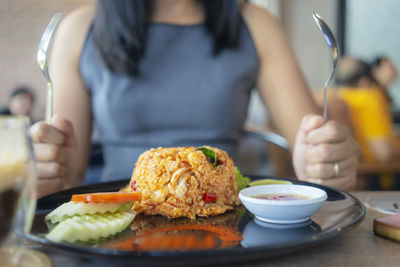 Midsection of woman having food in plate