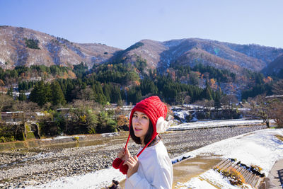 Portrait of woman standing in mountains during winter