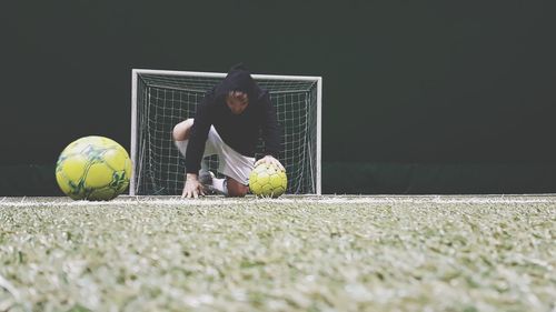 Boy playing soccer ball on field