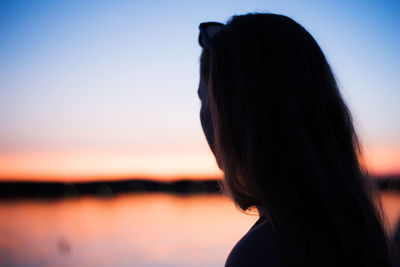 Side view of silhouette woman against sky during sunset