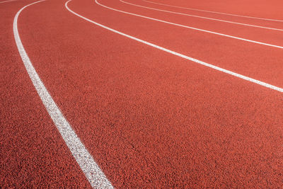 White markings on a red athletic race track in a sports stadium