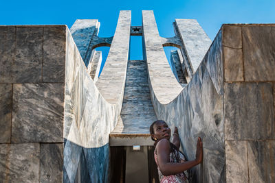 Portrait of young woman standing against sky