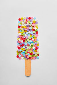 Directly above shot of multi colored candies against white background