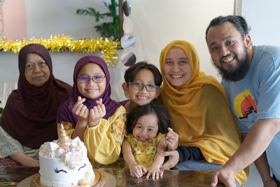 Portrait of cheerful family sitting at home