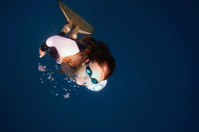 Directly above shot of mid adult woman swimming undersea
