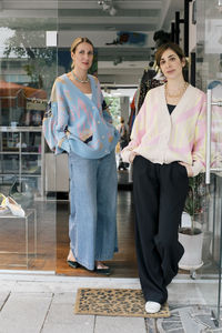 Portrait of female owners standing at doorway of boutique