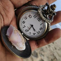 Close-up of hand pocket watch