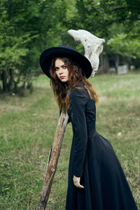 Portrait of young woman standing on field