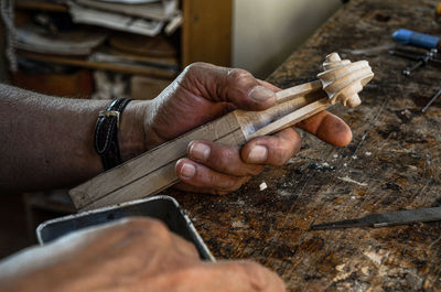 Violin maker luthier hand working a new violin scroll in cremona italy