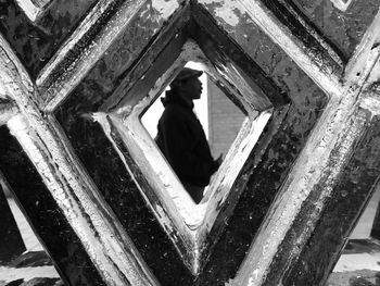 Silhouette man seen through old window