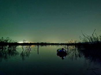 Scenic view of lake against sky at night