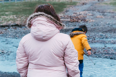 Rear view of mother with daughter in water