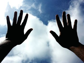 Low angle view of silhouette hand against sky