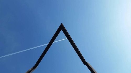 Low angle view of metal structure against blue sky