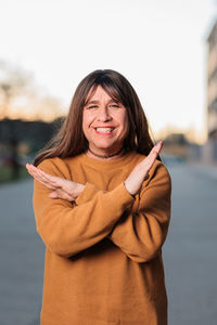 Portrait of smiling mature woman gesturing on road