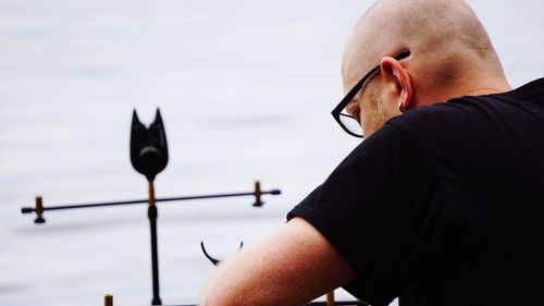 Close-up of bald man by lake