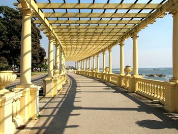 Walkway by sea against sky