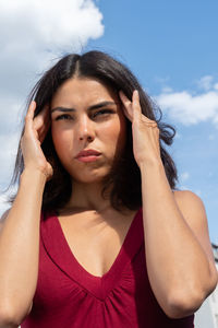 Woman with headache standing in standing in city