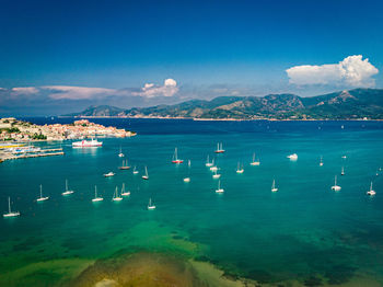 Aerial view of sailboats moored in sea against sky