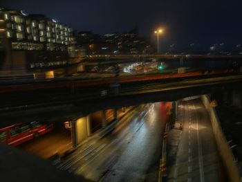 Light trails on road in city against sky at night