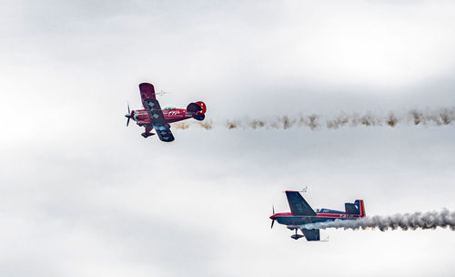 Low angle view of airplane flying against sky