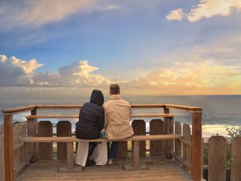 Rear view of couple looking at sea against sky