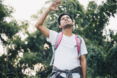 Full length of young man standing against plants