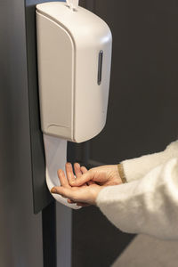 Woman using hand sanitizer dispenser