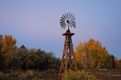 Traditional windmill on field against clear sky